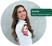 Junge Frau mit langen braunen Haaren hält einen LiveFresh Saft in der Hand und lächelt; eingeblendeter weißer Text auf grünem Hintergrund: „Leonie – Juice Cleanse expert“