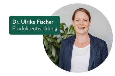 Zeigt Dr. Ulrike Fischer, die lächelnd in die Kamera blickt. Sie trägt eine dunkelblaue Jacke und ein weißes Oberteil. Links von ihr steht ihr Name und Titel in einem grünen Rechteck: „Dr. Ulrike Fischer, Produktentwicklung“. Im Hintergrund ist eine unscharfe Pflanze zu sehen.
