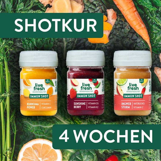 Drei LiveFresh Immun Shots Kurkuma Power Sunshine Berry und Ingwer Sturm auf dunklem Blattgemüse mit Gemüse und Orange. Darüber und darunter steht "Shotkur 4 Wochen".