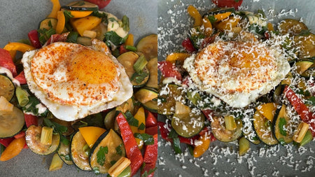 Eine Zucchini-Pfanne mit buntem Gemüse und einem Spiegelei, gewürzt mit Paprika und geriebenem Käse bestreut.