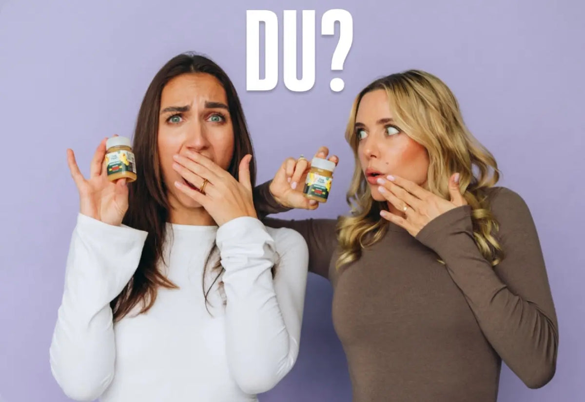 Zwei Frauen halten kleine Fläschchen mit Liv Fresh Ingwershots in den Händen und schauen überrascht. Beide bedecken ihren Mund mit einer Hand, während über ihnen der Schriftzug "DU?" steht.