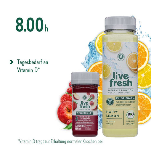 Live fresh Happy Lemon Flasche und Sunshine Berry Shot mit Zitrone Orange Cranberry Apfel Erdbeere vor Zitrusscheiben Wasser und Beeren als morgendlicher Start einer Saftkur. Der Text lautet 