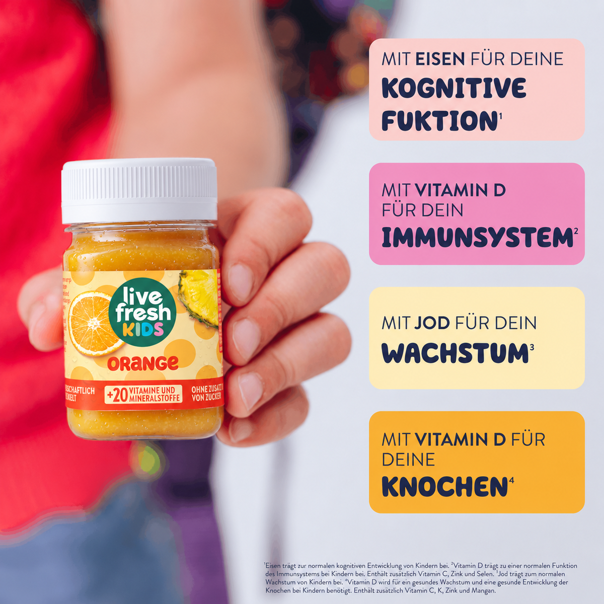 LiveFresh Kids Orange Drink mit orangefarbenem Etikett und Fruchtmotiven in einer Hand gehalten. Rechts sind vier farbige Infoboxen zu Eisen, Vitamin D und Jod sowie deren Funktionen für Kinder dargestellt.