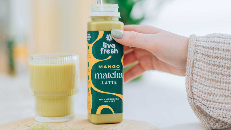 Mango Matcha Latte von LiveFresh mit einem Glasstrohhalm und einem Glas. 
