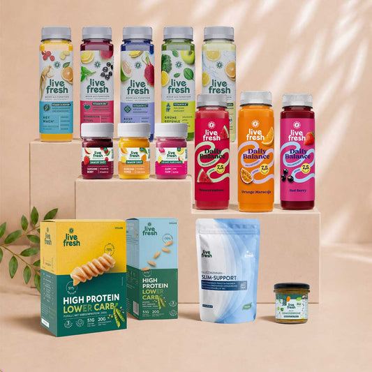 LiveFresh Produktauswahl mit Säften Daily Balance Drinks Immun Shots High Protein Lower Carb Produkten Slim Support und Gemüsebrühe auf beigefarbenen Podesten.