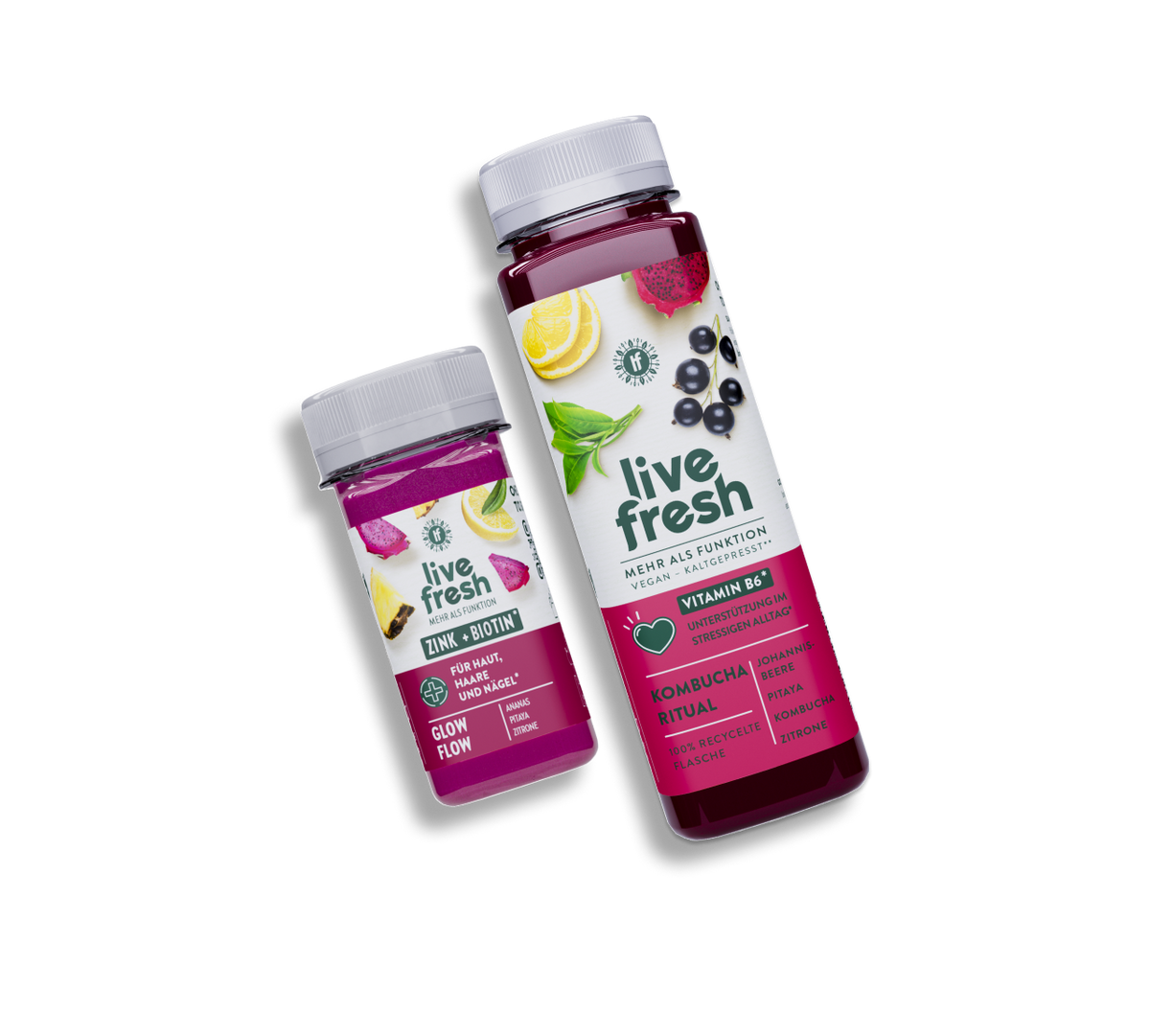 leicht schräg im Bild liegen ein pinker LiveFresh Shot "GlowFlow" mit Zitronen, Ananas und Pitaya auf dem Label und rechts daneben ein dunkel roter LiveFresh Saft "Kombucha Ritual" mit Zitrone, Pitaya, Teeblättern und Johannisbeere auf dem Label.